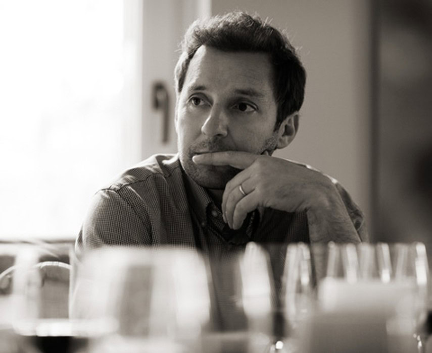 Thoughtful man at a wine tasting event, focusing on the wine selection.